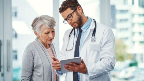 Doctor shows patient the DiviTum® TKa profile test for early prognosis and prediction of mBC treatment